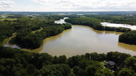 Vista-Aérea-De-Un-Hermoso-Estanque-Rodeado-De-Naturaleza-Y-Casas-Privadas-De-Lujo