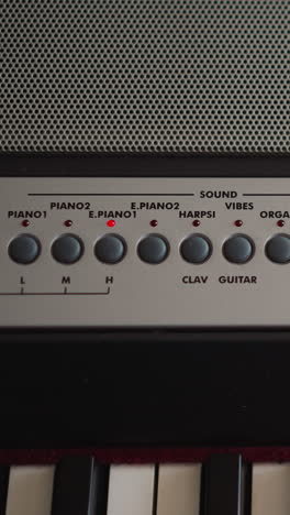 Child hand adjusts tempo turns on metronome and chooses mode on electrical piano control panel closeup. Kid prepares synthesizer to play musical melody