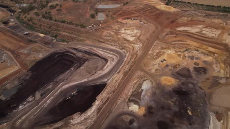 Small-open-cut-coal-mine-aerial-away-reveals-surrounding-brown-farmland