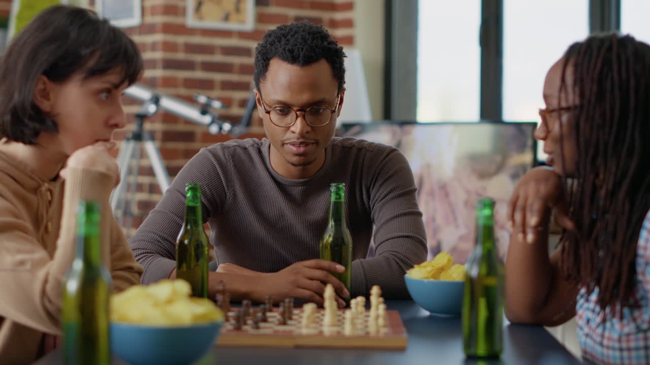 Portrait of african american man playing chess game with friends