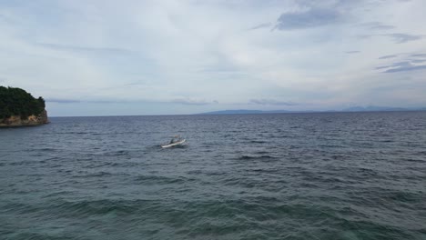 El-Disparo-Aéreo-De-Un-Dron-Desciende-Para-Revelar-A-Un-Pescador-Filipino-Montando-Un-Bote-Bangka-Hacia-El-Horizonte,-Catanduanes-Filipinas