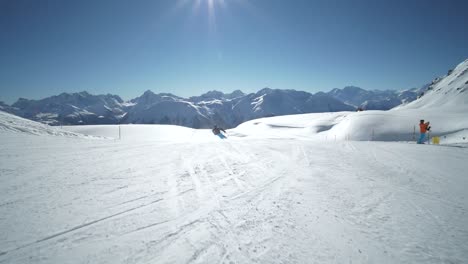 FOLLOW-TRACKING-SLOW-MOTION:-very-good-young-skier-skiing-on-a-beautiful-winter-day-on-perfect-slope-with-amazing-mountain-scenery-at-ski-resort-in-the-swiss-Alps-during-cloudless-day