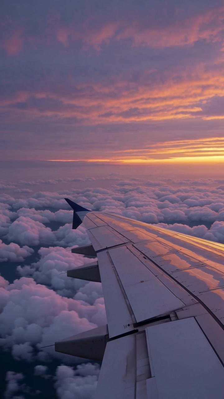 Vista dell'ala di un aereo sopra le nuvole durante il tramonto