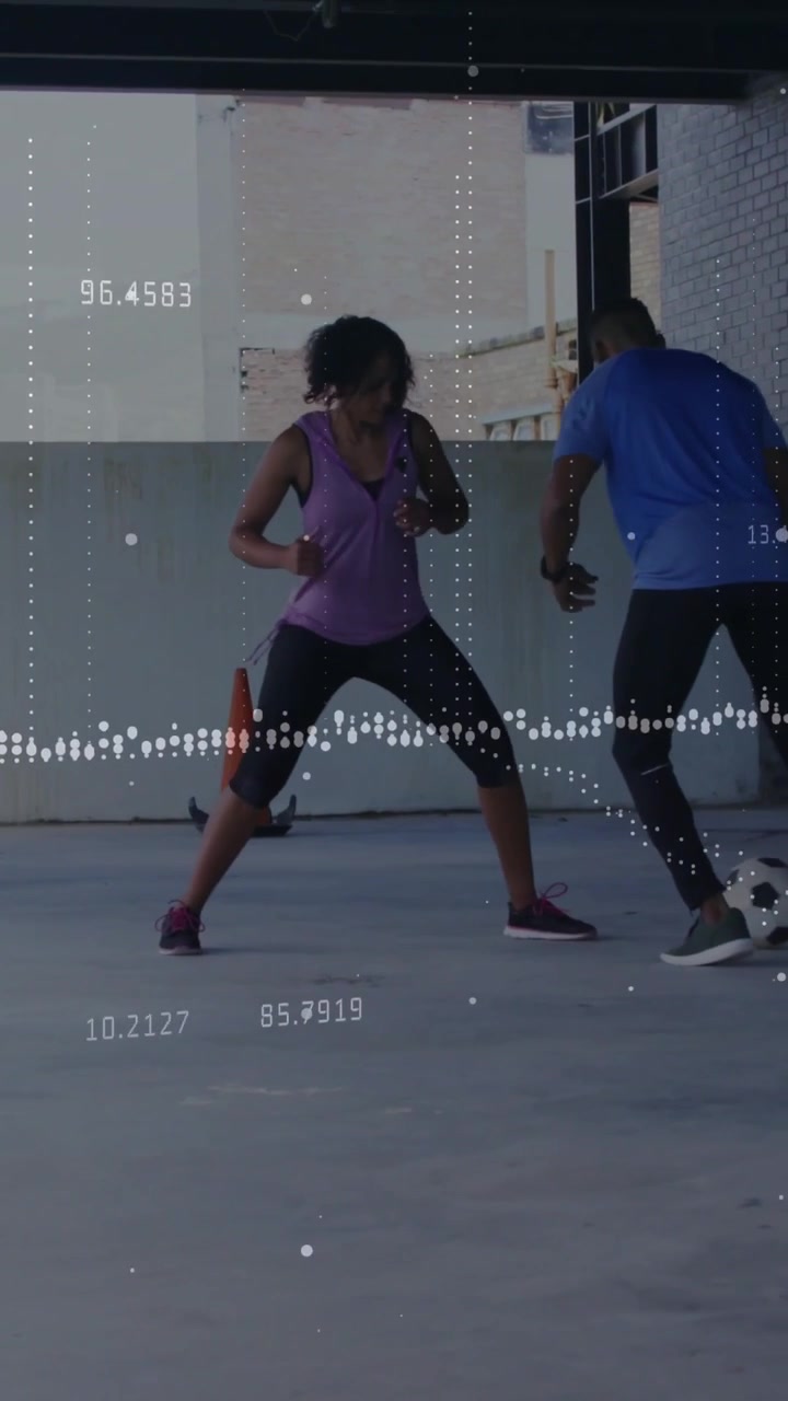 Vertical video: Man touching ball starting soccer drill, woman defending while overlay showing data
