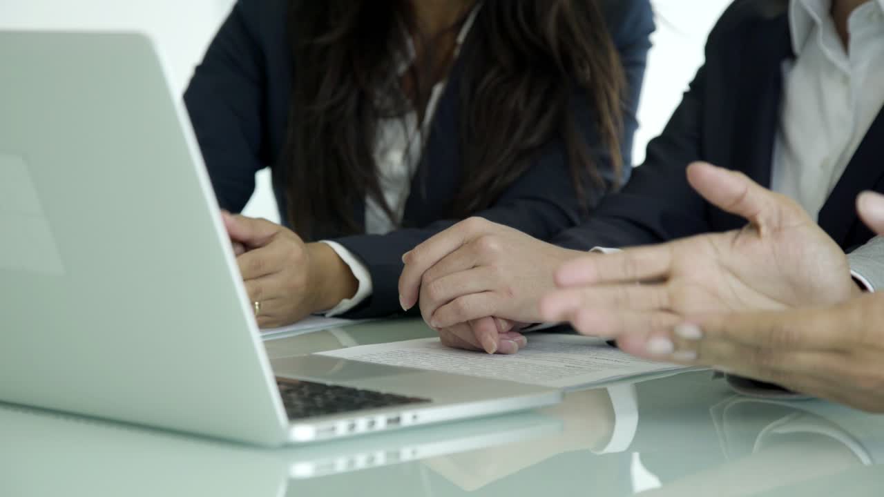 Inquadratura ravvicinata di professionisti seduti al tavolo con laptop