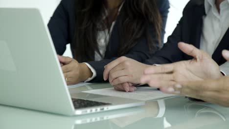 disparo recortado de personas de negocios sentadas en la mesa con una computadora portátil