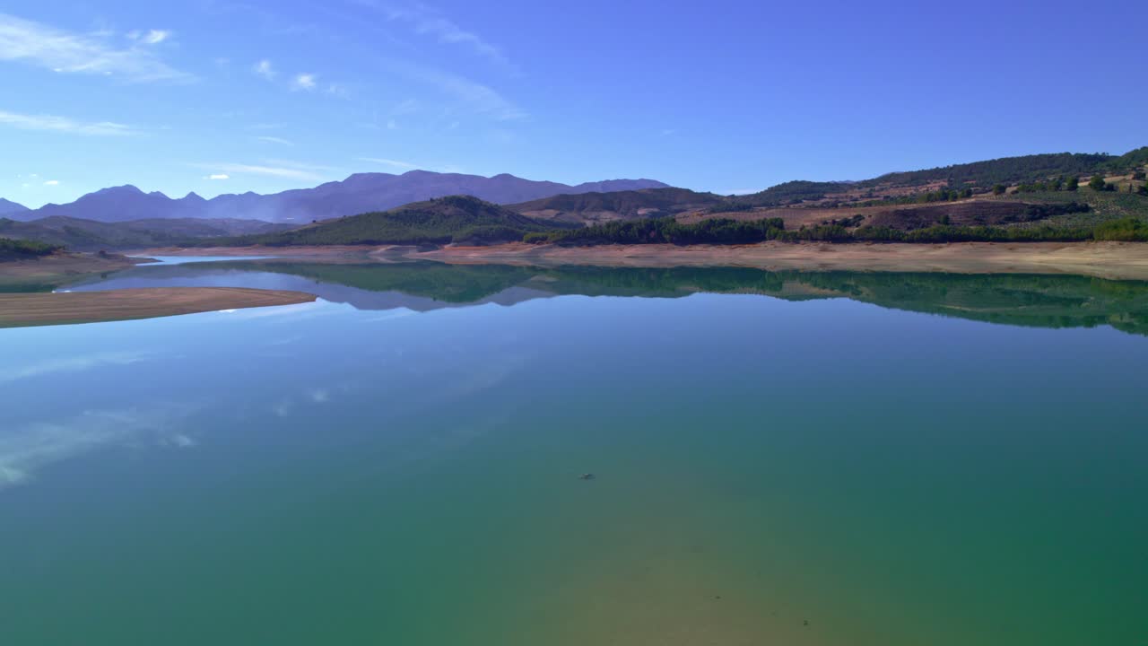 vuelo sobre aguas tranquilas y reflejo del paisaje en el espejo del agua