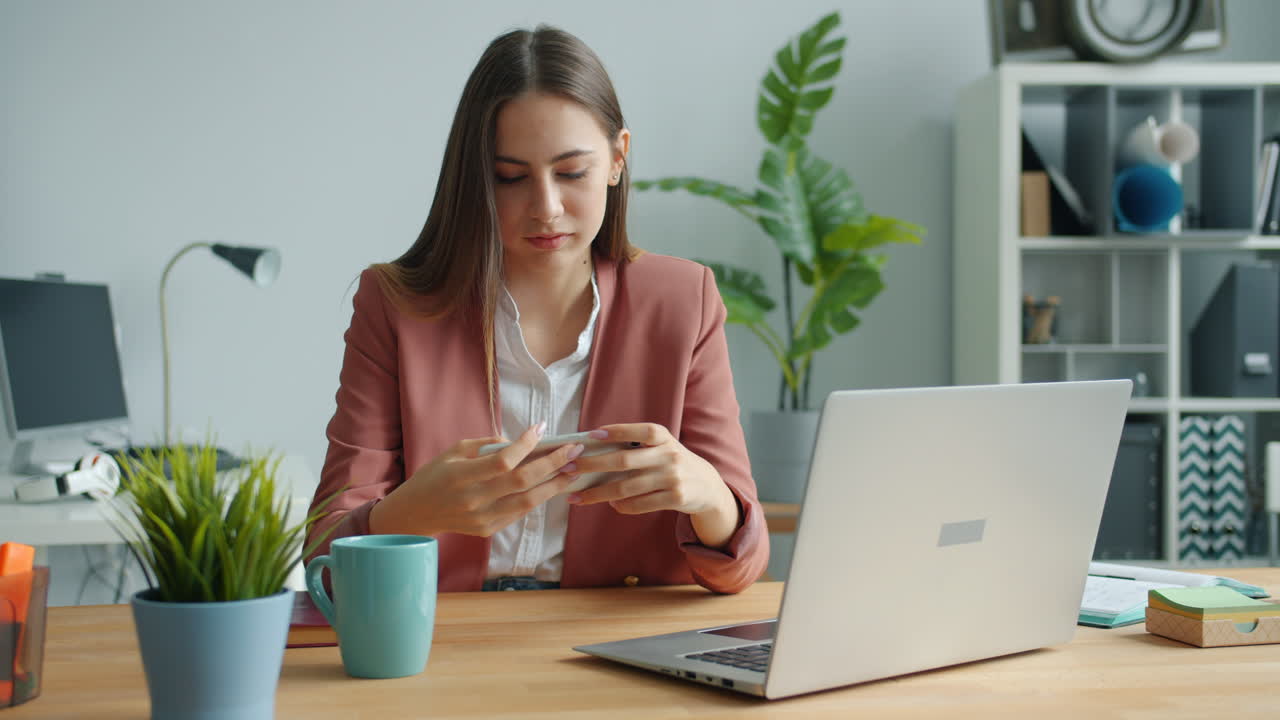 Woman working on smartphone in office