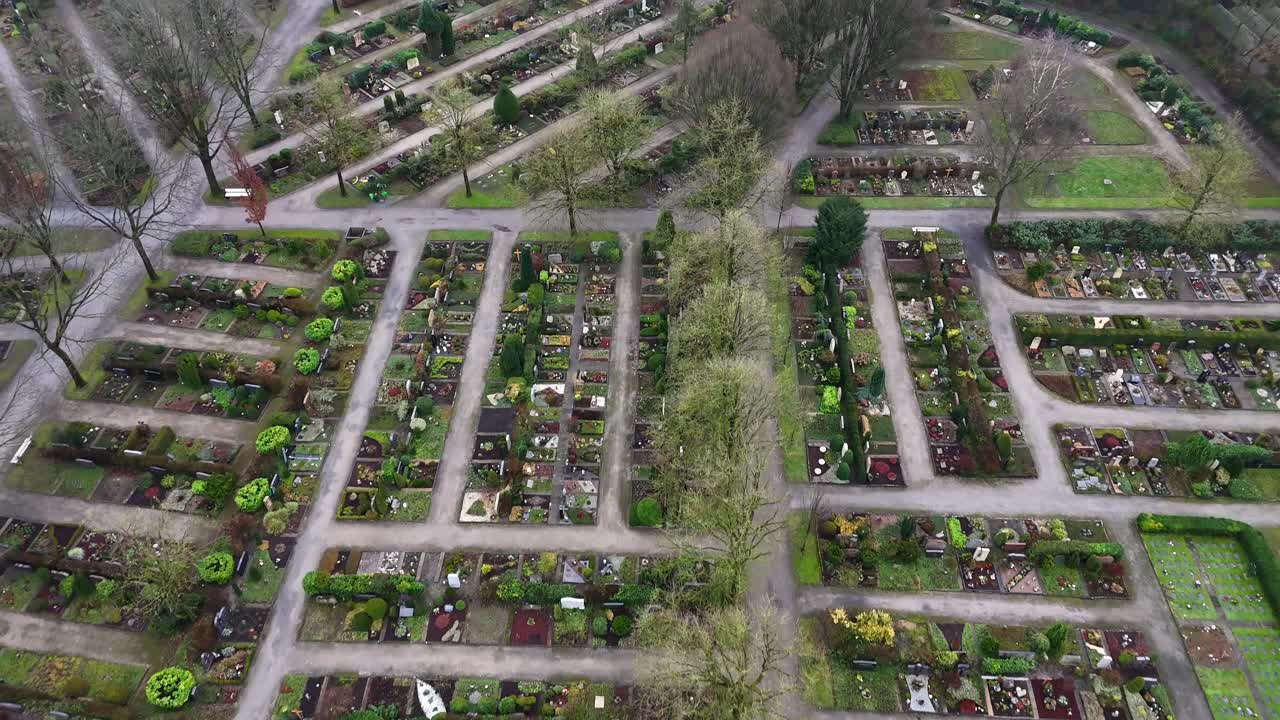 Aerial flyover cemetery with tombs on cloudy autumn day. Grass and graveyards in american suburb town. Birds Eye.