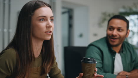 girl manager telling funny story to office coworkers sitting together close up.