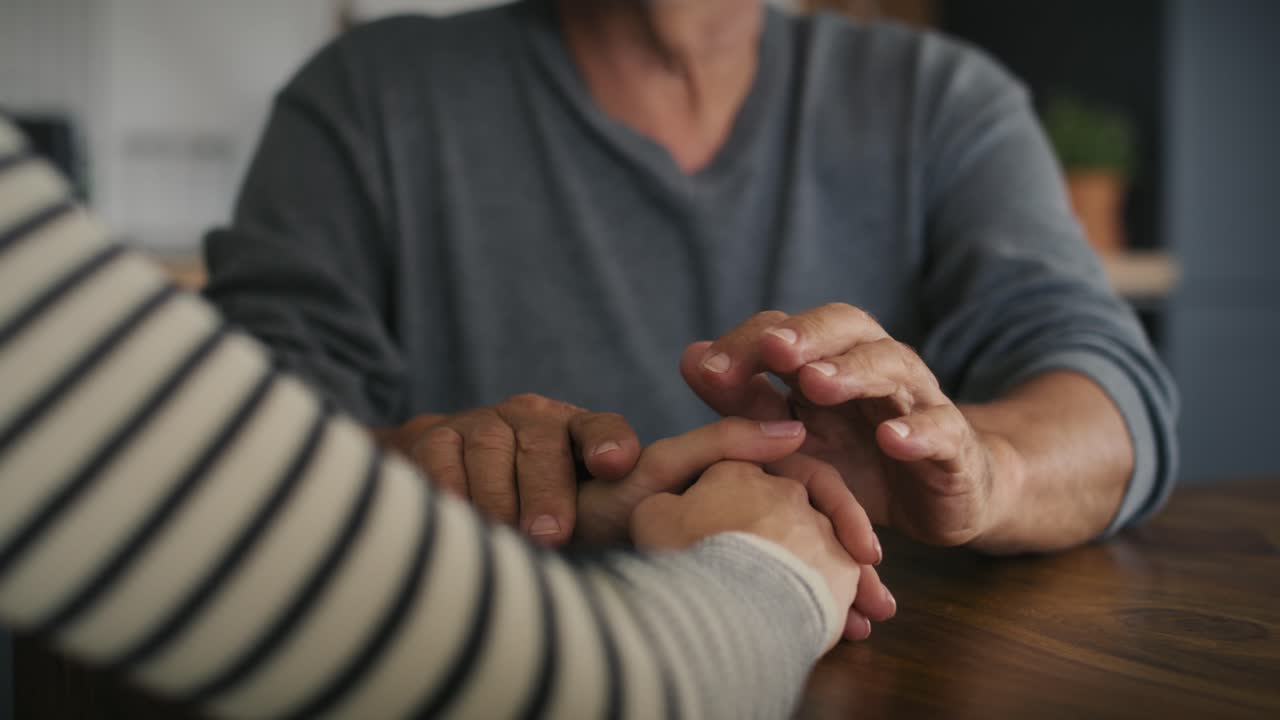 Part of man's hand support his adult daughter.