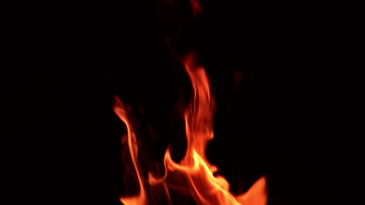 Fire flames rising in the air. Bonfire burning in the dark. Close up.