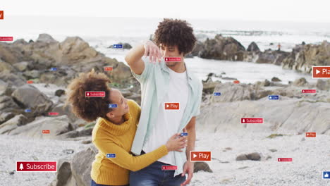 on rocky beach, couple with animation of social media icons around them
