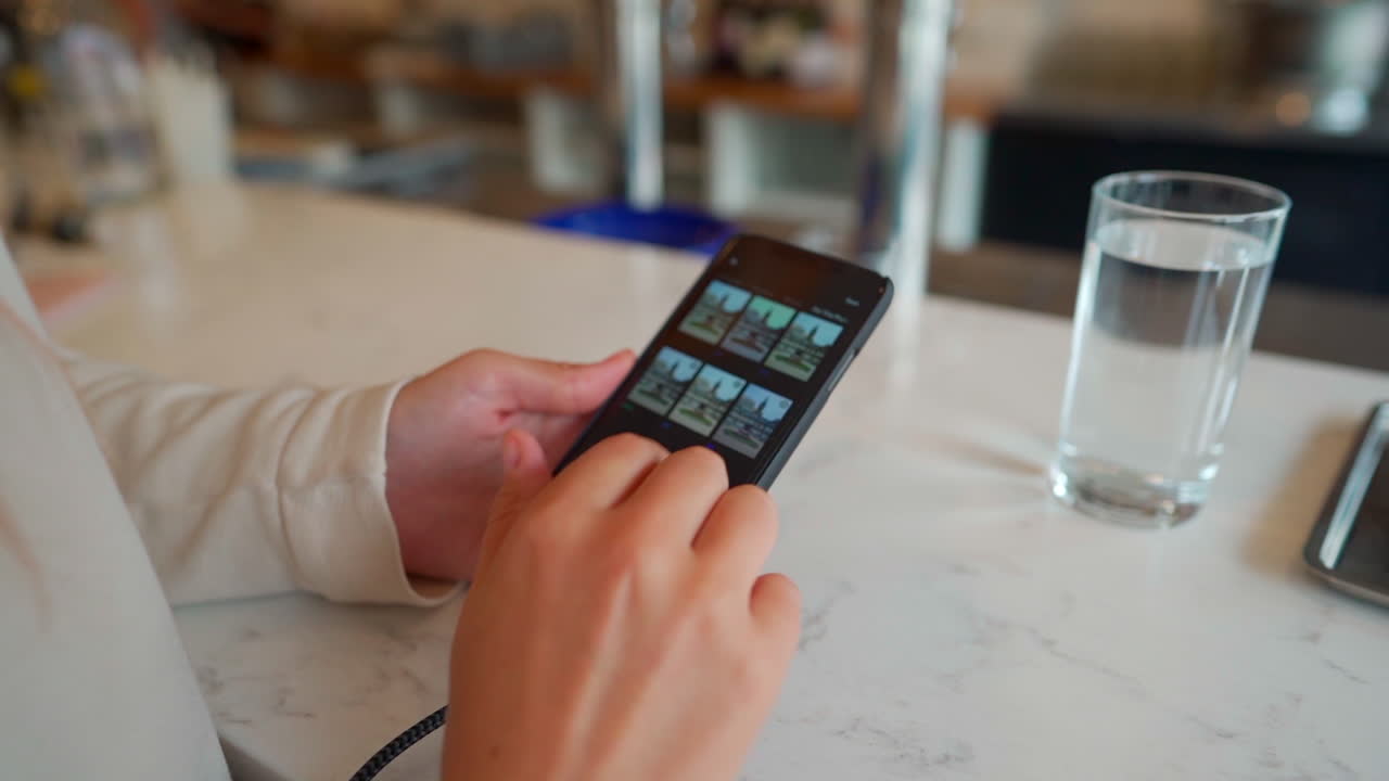 manos de mujer en el teléfono celular iphone escribiendo en un restaurante