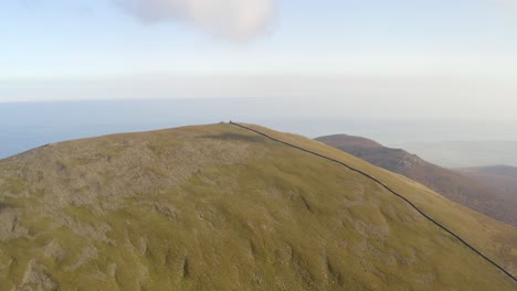 Aerial-view-of-the-beautiful-Slieve-Donard-summit-on-a-foggy-sunny-day