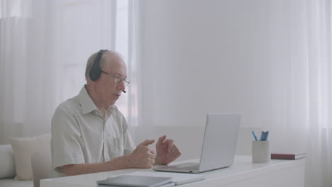 man is working on retirement consulting client online staying home using notebook with internet connection