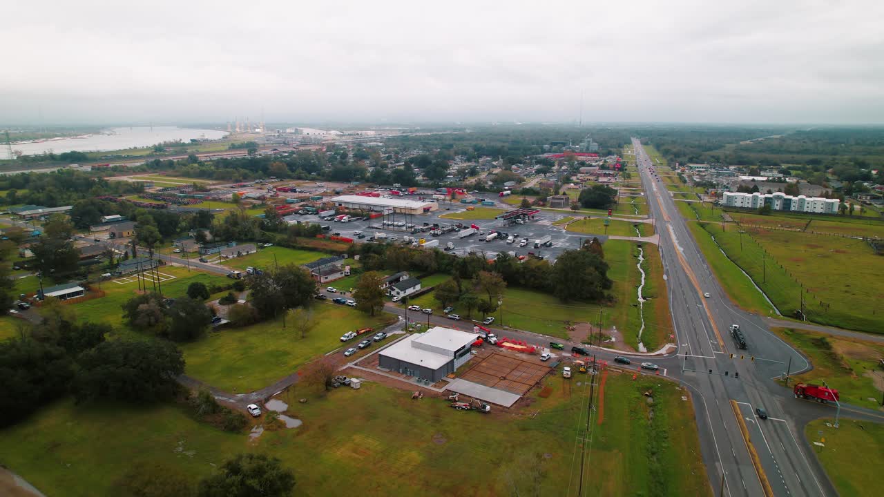 폭넓은 공중 전망에서 구름이 가득한 뉴올리언스 도로에 있는 저수지와 빨간색 덤프 트럭