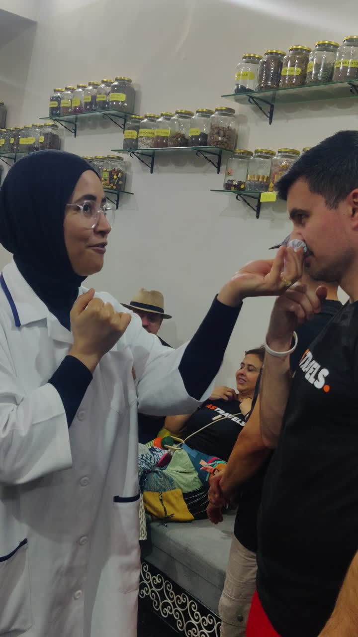 Vertical - Moroccan Men Sniffing Nigella Sativa At Koutoubia Herbal Shop In Marrakesh, Morocco.
