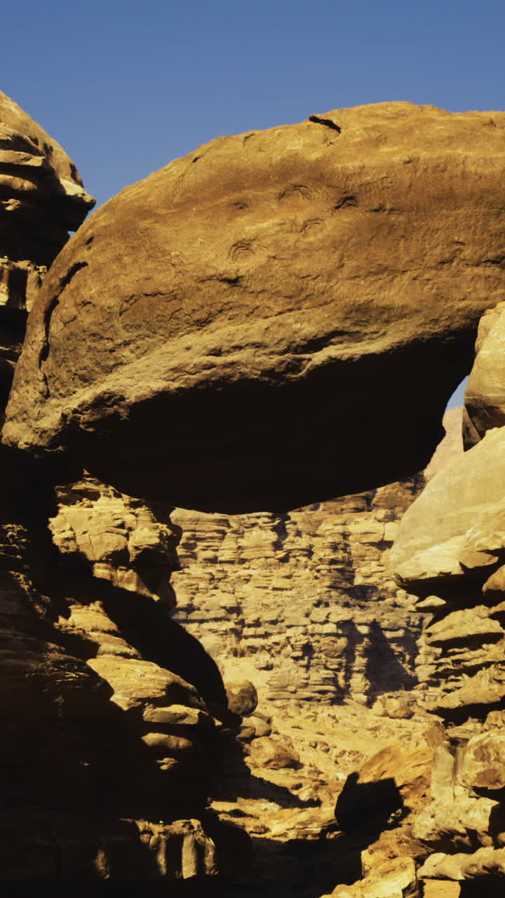 Majestic rock formation balancing between steep canyon walls in daylight