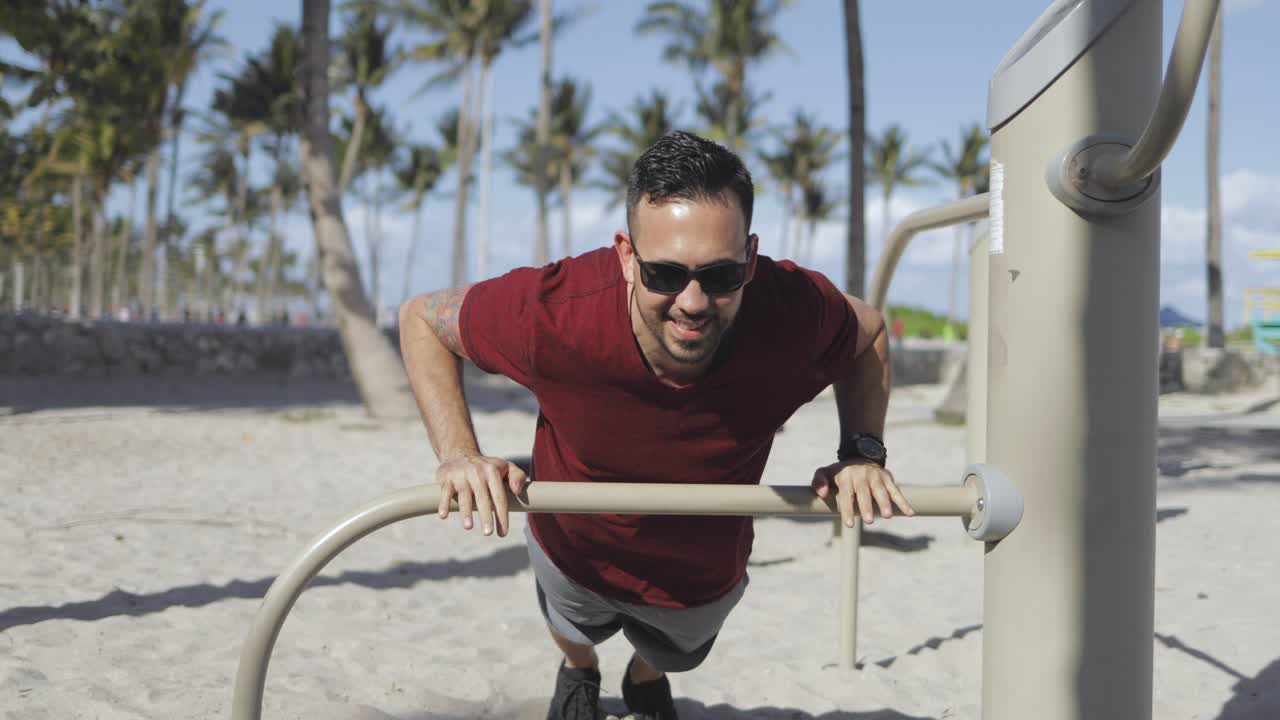 hombre serio entrenando en la playa de arena