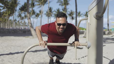 hombre serio entrenando en la playa de arena