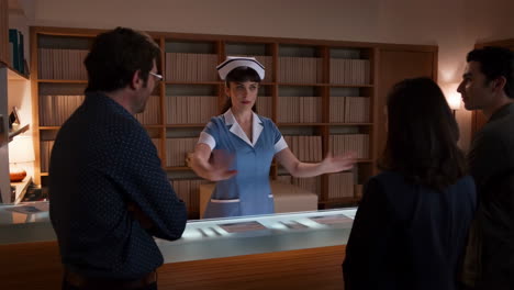 Nurse or receptionist in uniform interacts with people at a service counter
