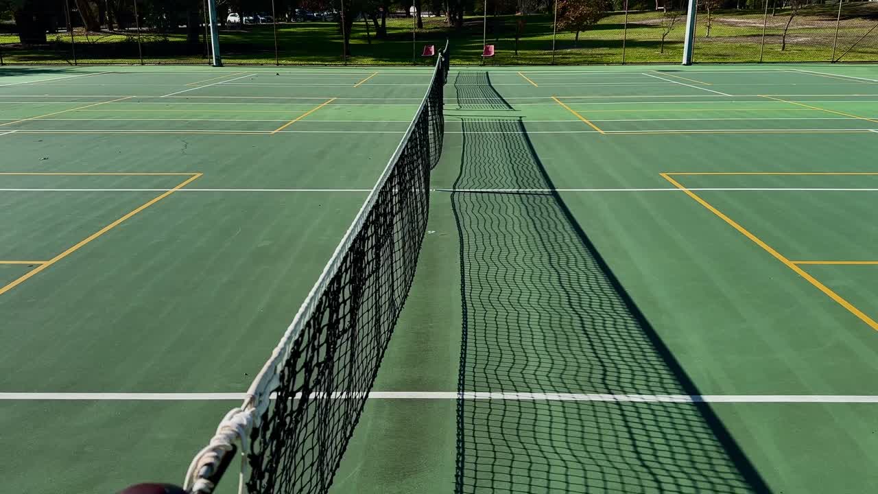 Tennis court closeup net looking down line of multiple courts Perth Australia