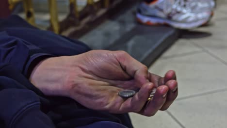 homeless holds coins tight grateful for support, close up