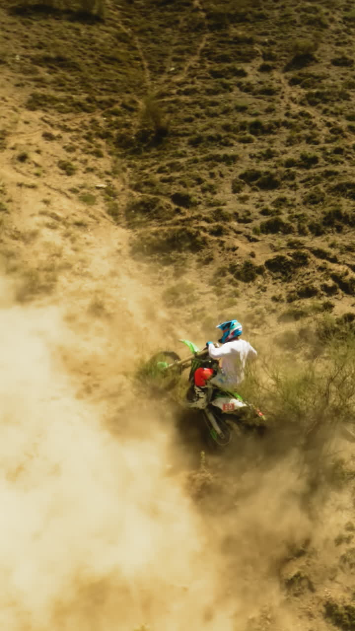 el piloto tiene problemas con el deslizamiento de la motocicleta en la colina del dron fpv. el deportista se ocupa de un accidente de motocicleta durante las carreras en las tierras altas del desierto. problemas offroad