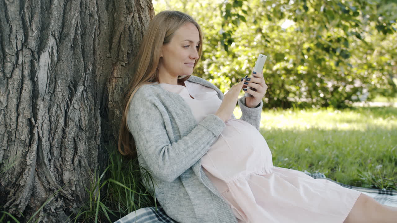 임신 한 여자 가 공원 에서 휴식 을 하고 있다