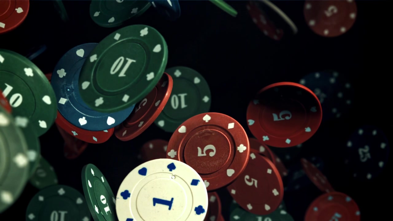 Fiches da poker colorate che fluttuano su uno sfondo nero.