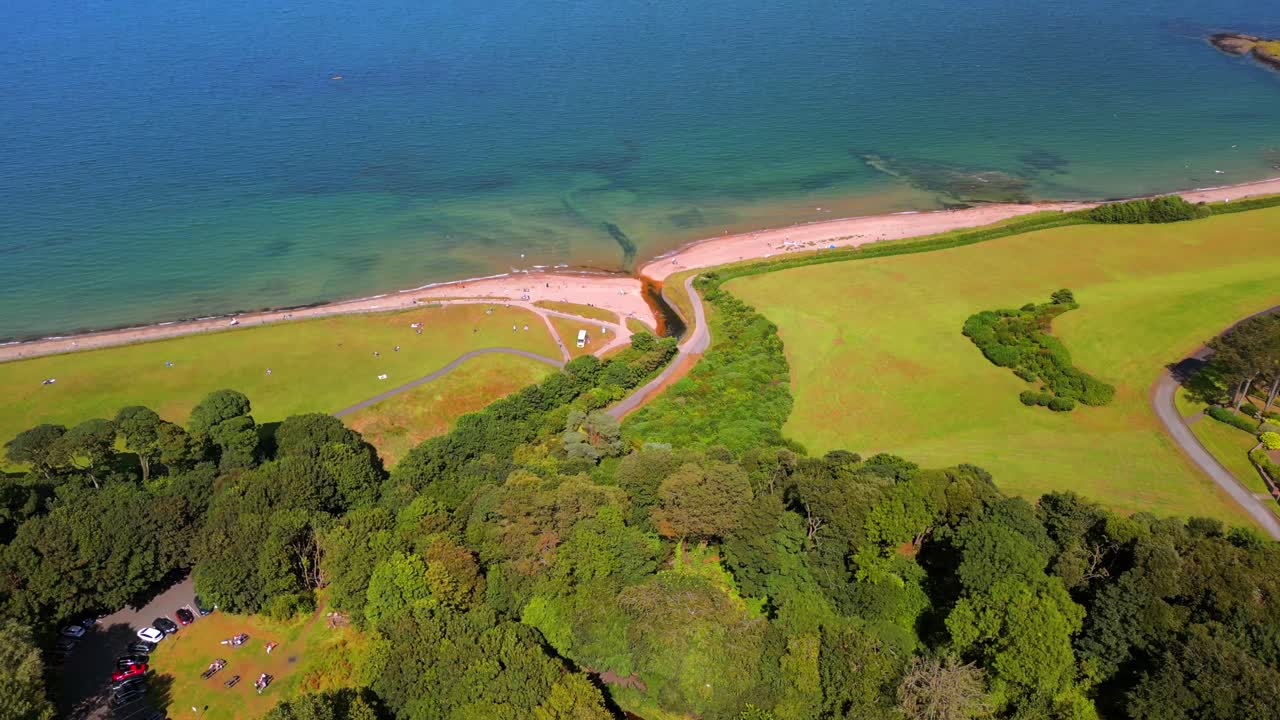 Advancing aerial video of Helen's Bay beach in County Down, Northern Ireland, UK on a bright summer day. Filmed in 4K, 60FPS and with Rec709 color