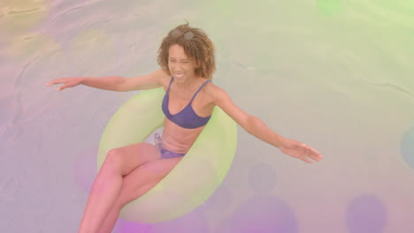 Smiling woman floating in pool on inflatable ring with colorful animation overlay