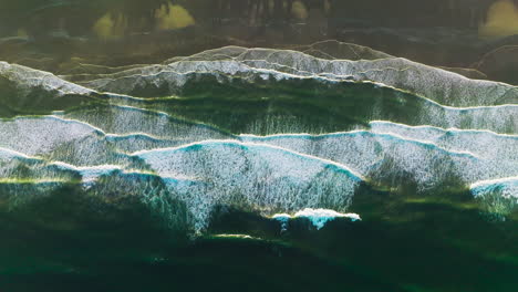amazingly beautiful foamy waves coming to the shore. pleasing sight of wide tide covering the beach from bird's eye view.