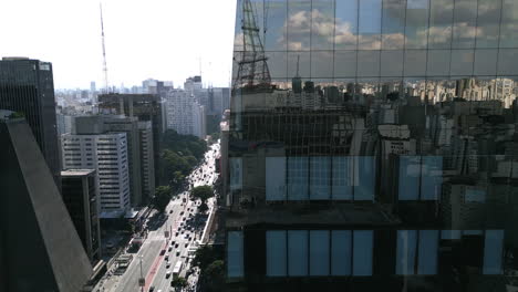 imágenes aéreas que revelan el bulevar principal en são paulo desde detrás de un rascacielos reflectante