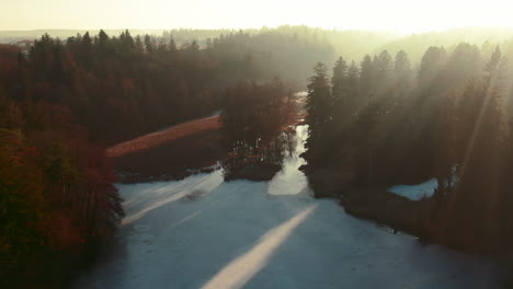 Winter-See-Drohne-Flug-Antenne-Gefrorenes-Wasser-Wald-Kiefern-Sonnenuntergang-Sonnenlicht-Lichtstrahlen-Pruhonice-Tschechien