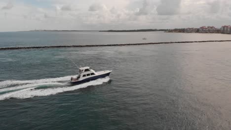 Aerial-View-Following-Boat-Driving-into-City-Skyline