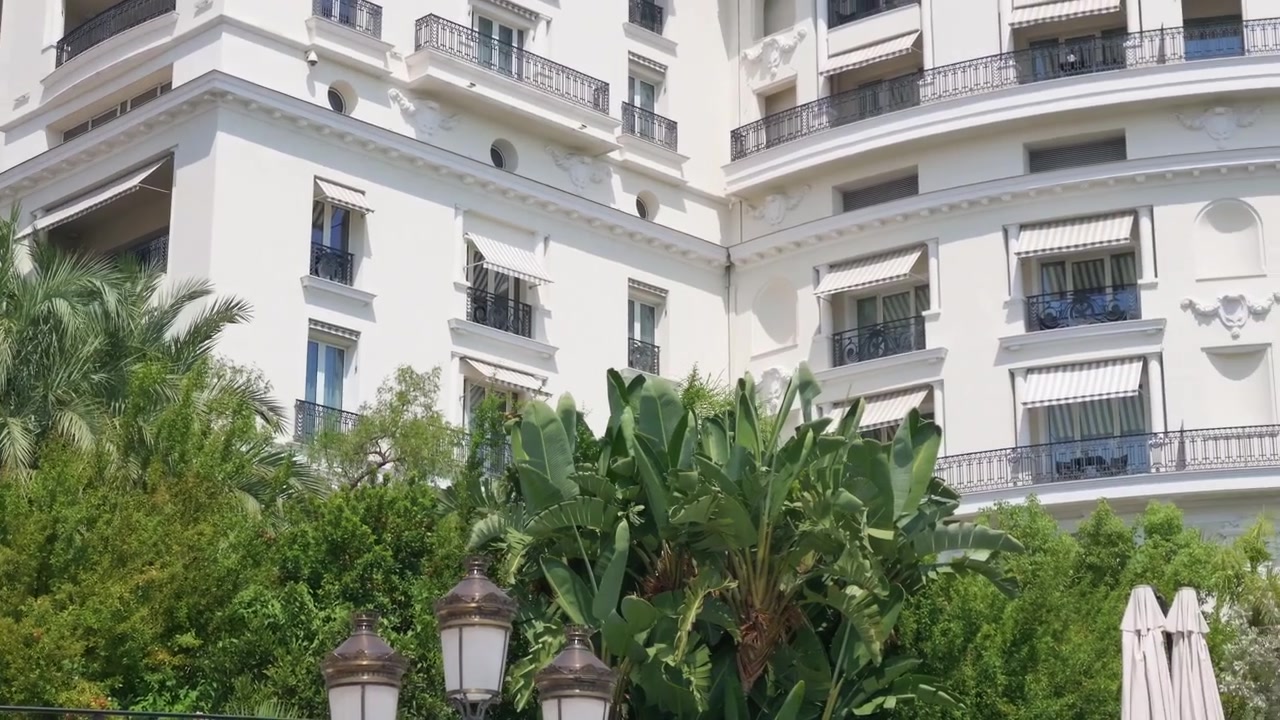 Vista della cupola verde e delle torri del casinò sopra terrazze giardino con ombrelloni e palme, Monte Carlo, Monte Carlo, Monaco