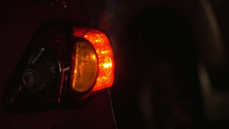 Car-with-hazard-lamps-at-rainy-night