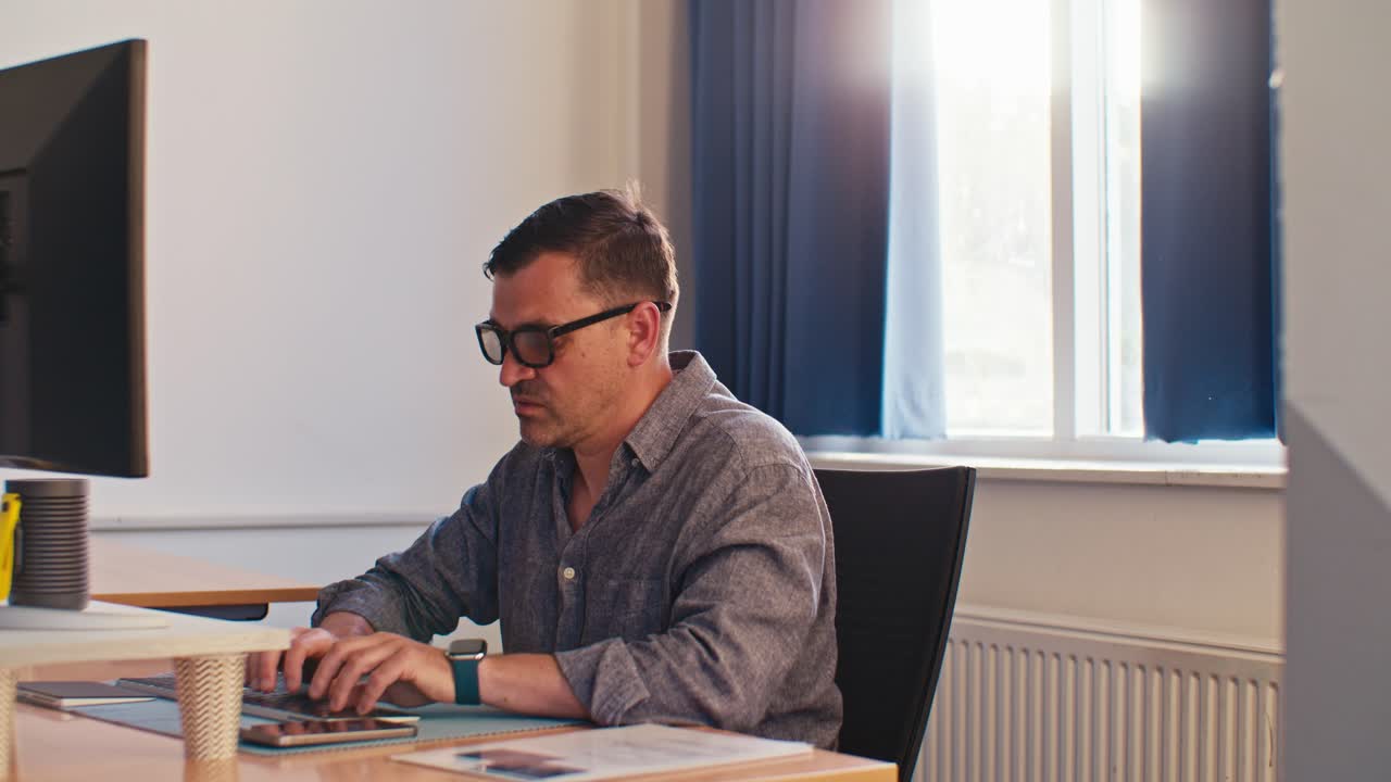 busy European Caucasian white male man model doing job working in the office on PC, typing on keyboard on desktop