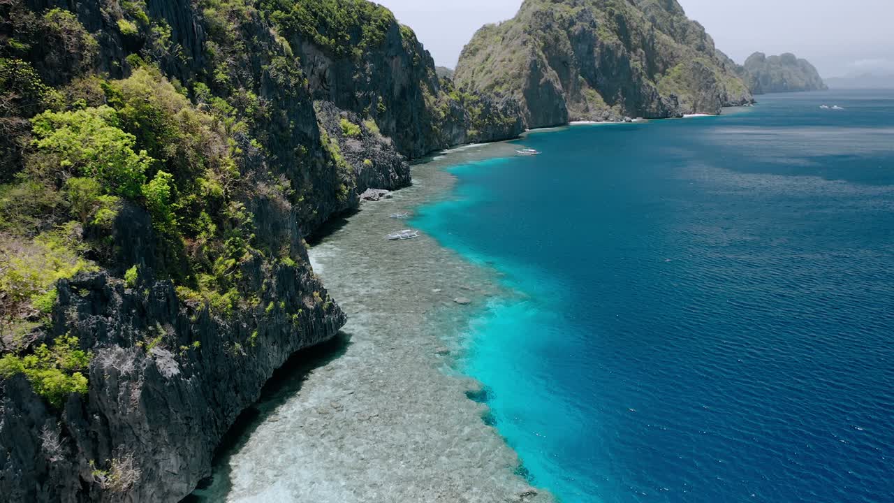 관광 보트, 바위 산과 마틴로크 사원 근처의 산호초 위를 날아다니는 영상. - 엘 니도, 팔라완, 필리핀