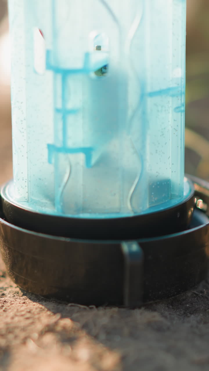 바닥에 있는 플라스틱 컨테이너의 클로즈업, 배경에는 잔디가 있고, 아마도 동물에게 먹이를 주거나 물을 주기 위해 사용되었을 것입니다.