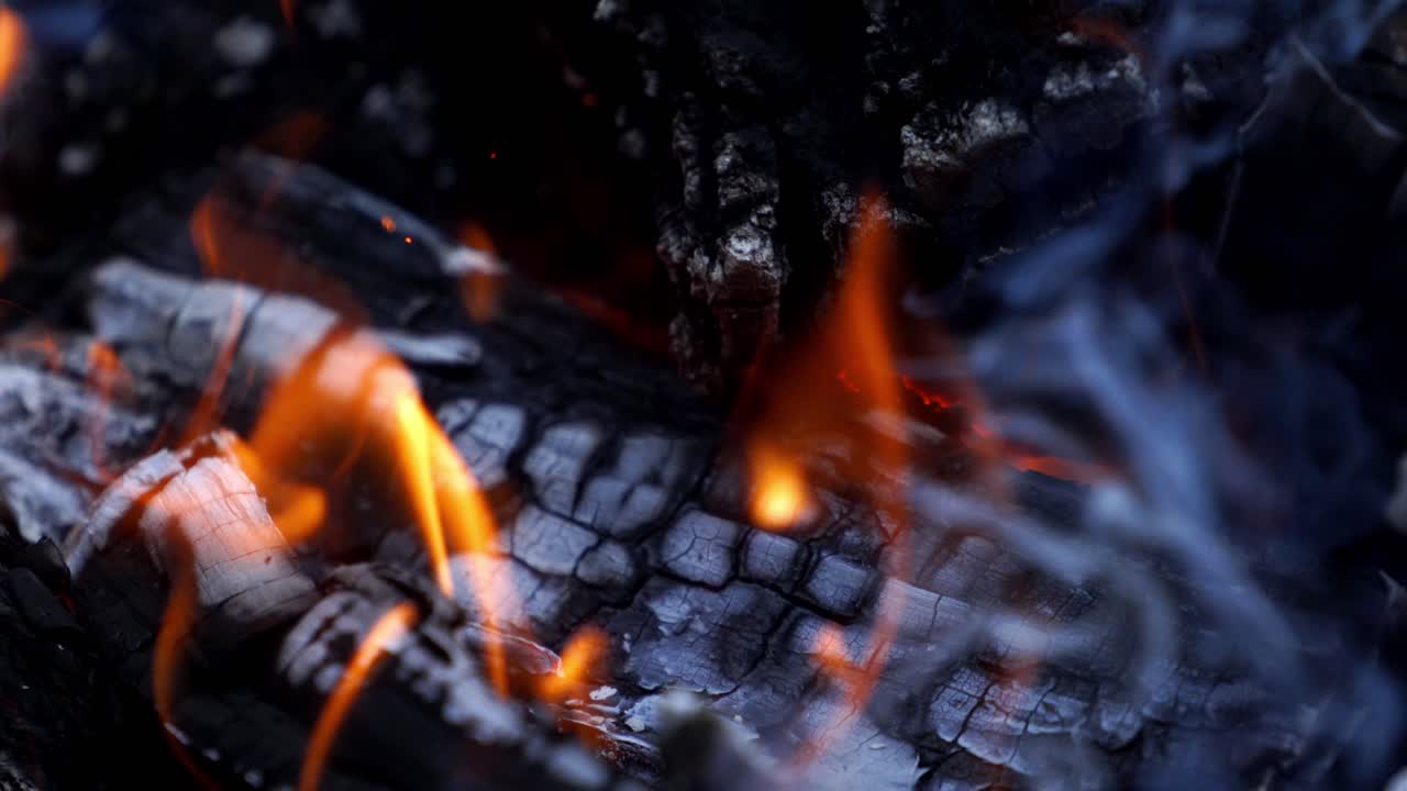 Bonfire. Burning logs in orange flames. Beautiful fire burns brightly. Embers of the fire climb up. Slow motion