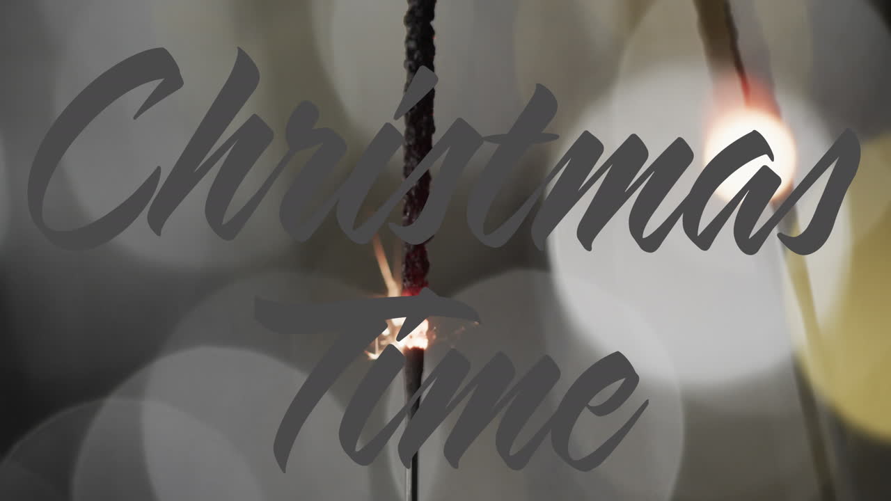Animation of christmas time text over lit sparklers background