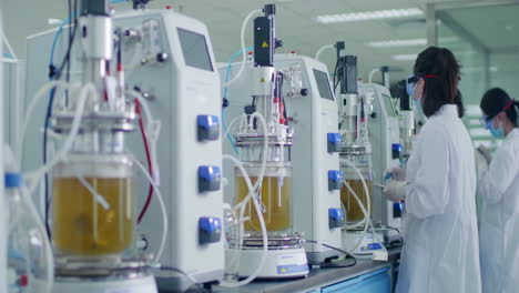 medical research scientists conducting biological experiment on cell culture essay with help of high tech equipment machine lab in cleanroom environmental facility