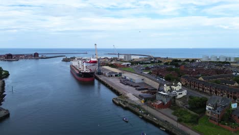 tomada aérea de un dron del puerto de sunderland con un gran buque de carga atracado en el río wear