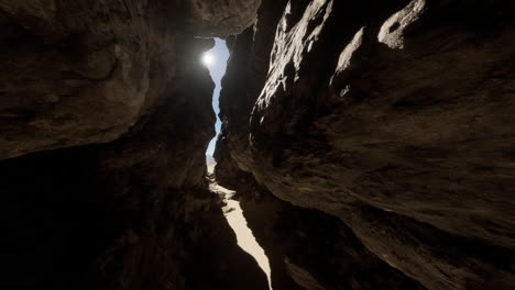 a view through a narrow canyon, with sunlight shining through the rocks