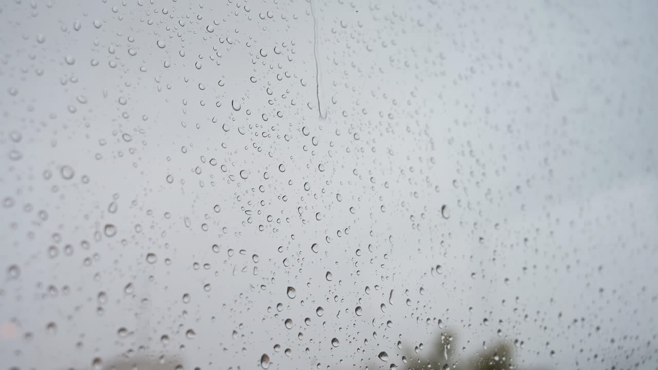 가 ⁇ 운 비 방울의 느린 움직임의 클로즈업 영상이 창문 유리를 통해 볼 수 있습니다.