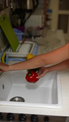 washing bell peppers in the kitchen sink
