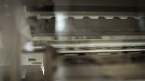 inside of a printing machine, parts moving on the produsction line